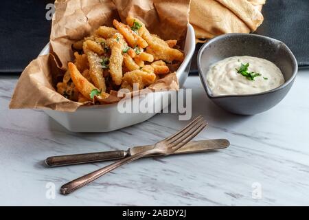 New England fried clam strips served with a bowl of tartar dipping sauce Stock Photo