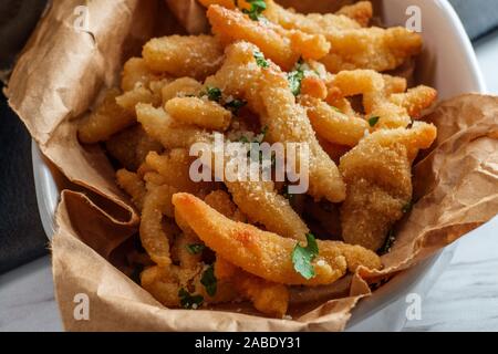 New England fried clam strips served with a bowl of tartar dipping sauce Stock Photo