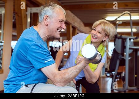 Senior man doing dumbbell exercise in the gym Stock Photo
