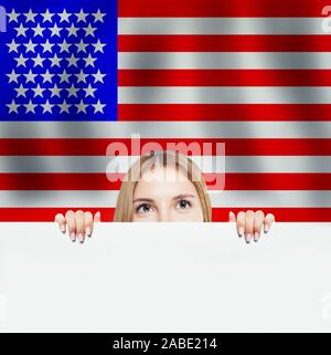 Portrait of happy american girl with white paper against the USA flag background. Travel and learn english language concept Stock Photo