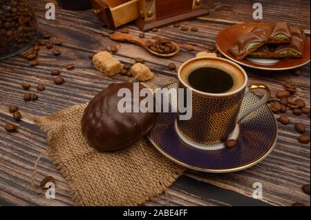 A Cup of coffee, marshmallows in chocolate, coffee beans, brown sugar on a wooden background. Close up Stock Photo