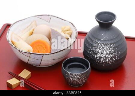 Japanese traditional sake cup and bottle with oden on tray Stock Photo