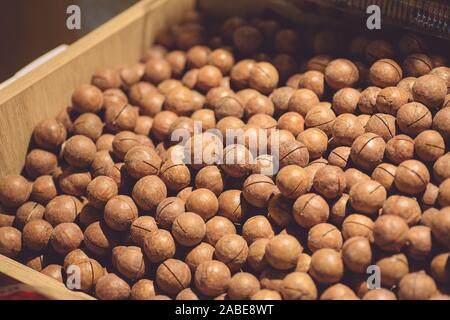 Macadamia nuts on a market counter. Inshell Macadamia Nuts. Stock Photo