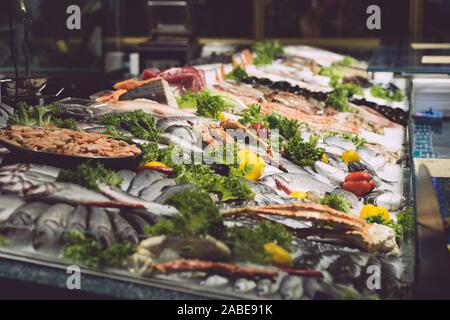 Fresh fish and seafood in a fish market window display. Variety and types of oceanic seafood for sale in a restaurant. Stock Photo