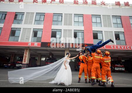 Fireman Jia Jie and his wife take unique pictures with the help of his colleagues in front of a fire fighting truck in Chengdu city, southwest China's Stock Photo