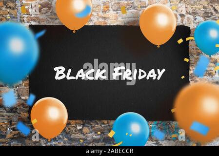 Black Friday poster on wall surrounded with ballons and confetty. Concept of shopping holiday promotion. Stock Photo