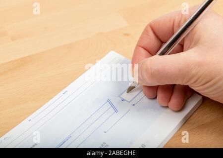 Person filling a bank check Stock Photo