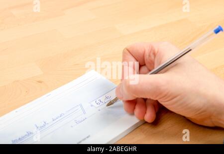 Person filling a bank check Stock Photo
