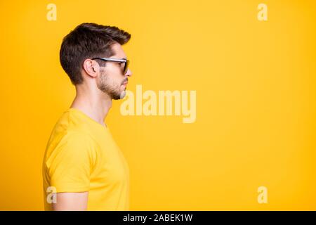Profile photo of handsome guy looking empty space not smiling reliable person listen boss wear sun specs casual t-shirt isolated bright yellow color Stock Photo