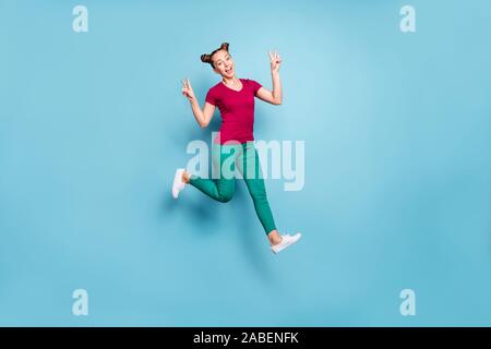 Full length body size turned photo of cheerful positive cute pretty nice charming girlfriend showing double v-sign while running and jumping isolated Stock Photo