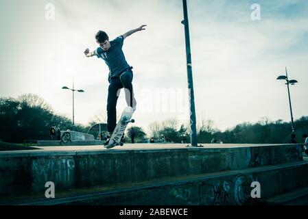 Skateboarders ollie off high steps onto the concrete below, dangerous adventure, extreme sports, professional skaters, Skateboarding Stock Photo