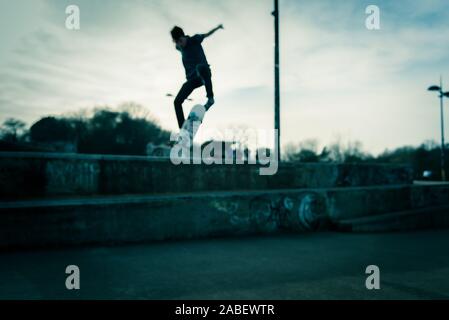 Skateboarders ollie off high steps onto the concrete below, dangerous adventure, extreme sports, professional skaters, Skateboarding Stock Photo