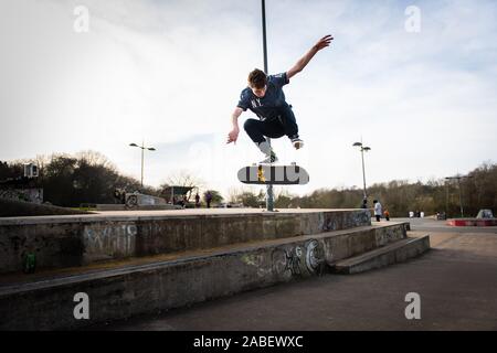 Skateboarders ollie off high steps onto the concrete below, dangerous adventure, extreme sports, professional skaters, Skateboarding Stock Photo