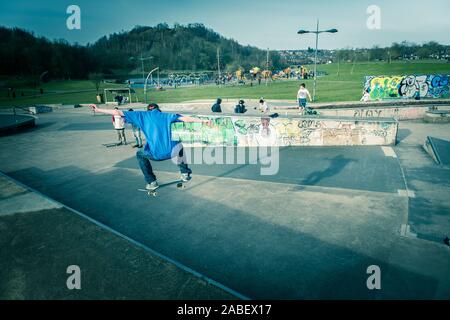 Skateboarders ollie off high steps onto the concrete below, dangerous adventure, extreme sports, professional skaters, Skateboarding Stock Photo