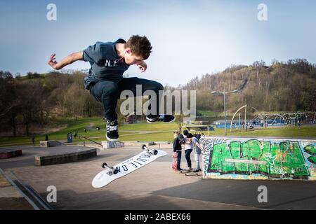 Skateboarders ollie off high steps onto the concrete below, dangerous adventure, extreme sports, professional skaters, Skateboarding Stock Photo