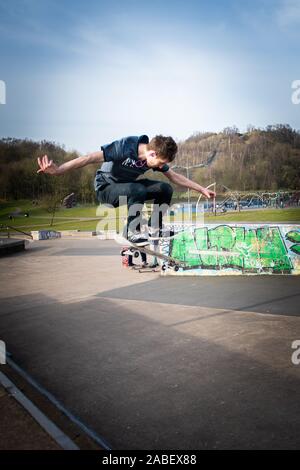 Skateboarders ollie off high steps onto the concrete below, dangerous adventure, extreme sports, professional skaters, Skateboarding Stock Photo