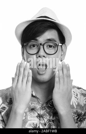 Face of young handsome Asian tourist man looking shocked Stock Photo