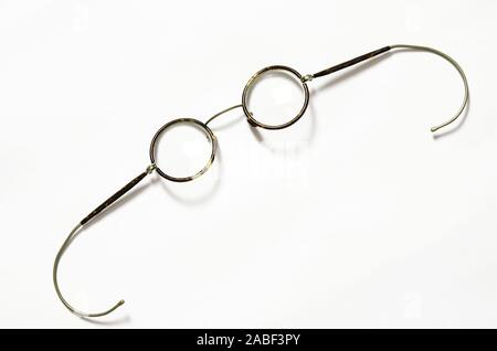 Round old eyeglasses for vision correction lie on a white background Stock Photo