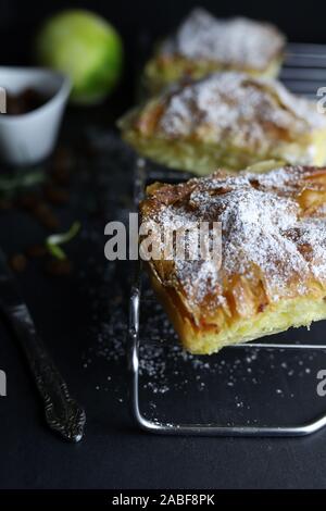 Concept of Greek cuisine. Homemade traditional greek Bougatsa, phyllo pastry filled with cream and sultanas on dark background.Top view Stock Photo