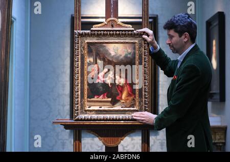 Art dealer Carlo Milano places a newly discovered work by Lavinia Fontana entitled Mystic Marriage of St. Catherine on an easel during a photo call for London Art Week at the Weiss Gallery in St James', London. Stock Photo
