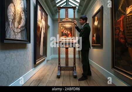 Art dealer Carlo Milano places a newly discovered work by Lavinia Fontana entitled Mystic Marriage of St. Catherine on an easel during a photo call for London Art Week at the Weiss Gallery in St James', London. Stock Photo