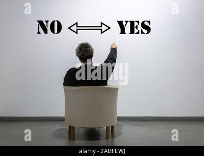 a man in front of the words yes or no chooses yes - Concept of decision making Stock Photo