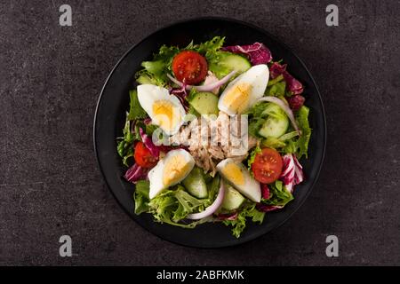Salad with tuna, egg and vegetables on black background Stock Photo