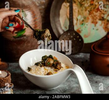 woman eating azerbaijani pilaf rice served with sabzi govurma Stock Photo