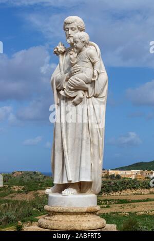 Marble statue of male figure holding long flower sten and young child at the National Shrine of the Blessed Virgin of Ta' Pinu, Gozo, Malta. Stock Photo