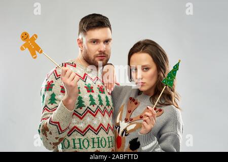 couple with christmas party props in ugly sweaters Stock Photo