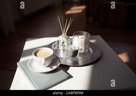 coffee, candles and aroma reed diffuser on table Stock Photo