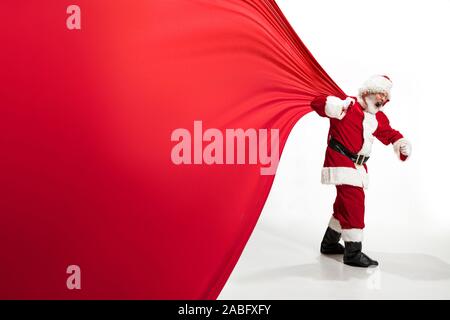 Santa Claus pulling huge bag full of christmas presents isolated on ...