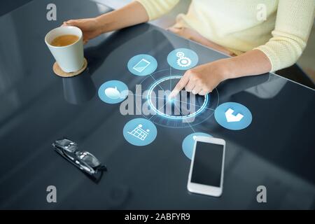 woman with coffee using black interactive panel Stock Photo
