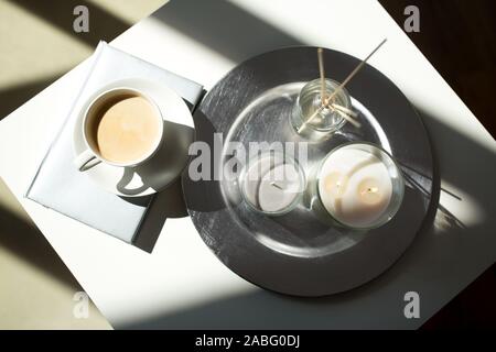 coffee, candles and aroma reed diffuser on table Stock Photo