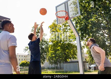 group of male friends playing street basketball Stock Photo