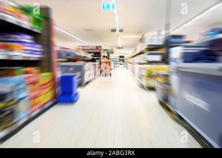 Abstract blurred supermarket aisle with modern shelves and goods for shopping, copy space Stock Photo