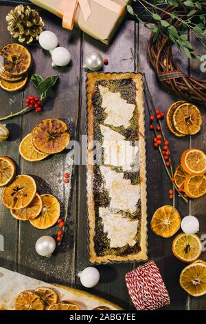Freshly baked christmas tart  on a wooden background with various christmas decoration Stock Photo