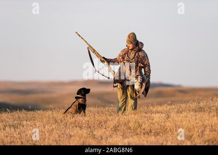 A Young Goose hunter with his Black Labrador Retriever Stock Photo