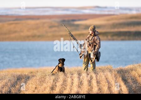 A Young Goose hunter with his Black Labrador Retriever Stock Photo