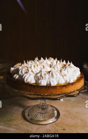 Lemon tart with french meringue caramelized on top, on a rustic table, french meringue caramelized with a food torch. Stock Photo