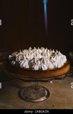 Lemon tart with french meringue caramelized on top, on a rustic table, french meringue caramelized with a food torch. Stock Photo