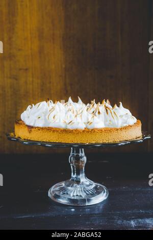 Lemon tart with french meringue caramelized on top, on a rustic table, french meringue caramelized with a food torch. Stock Photo