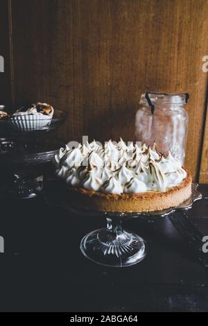 Lemon tart with french meringue caramelized on top, on a rustic table, french meringue caramelized with a food torch. Stock Photo