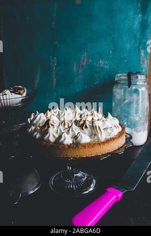 Lemon tart with french meringue caramelized on top, on a rustic table, french meringue caramelized with a food torch. Stock Photo