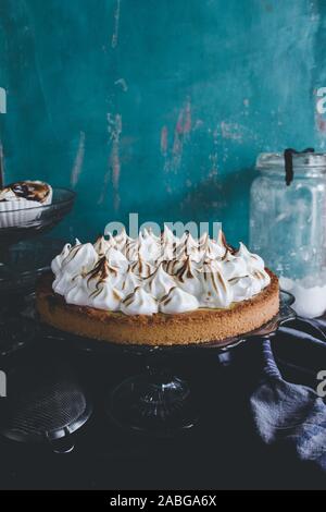 Lemon tart with french meringue caramelized on top, on a rustic table, french meringue caramelized with a food torch. Stock Photo