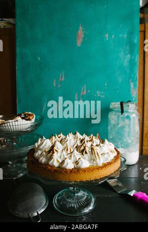 Lemon tart with french meringue caramelized on top, on a rustic table, french meringue caramelized with a food torch. Stock Photo