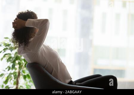 Millennial businesswoman relax in office chair dreaming Stock Photo