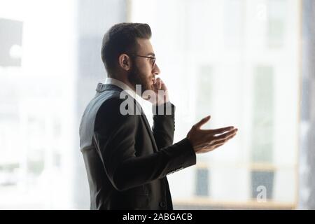 Young Arabic businessman talk on cellphone in office Stock Photo
