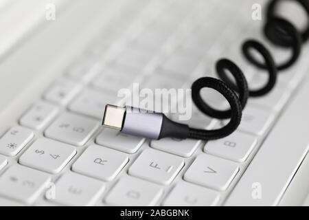 Usb type c cable against laptop keyboard background. Stock Photo