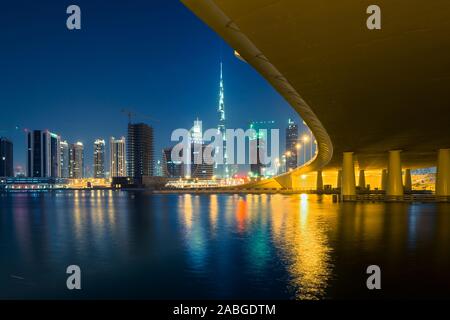 Night view of skyline of new Business Bay District towards Burj Khalifa tower  from The Creek river in Dubai United Arab Emirates Stock Photo